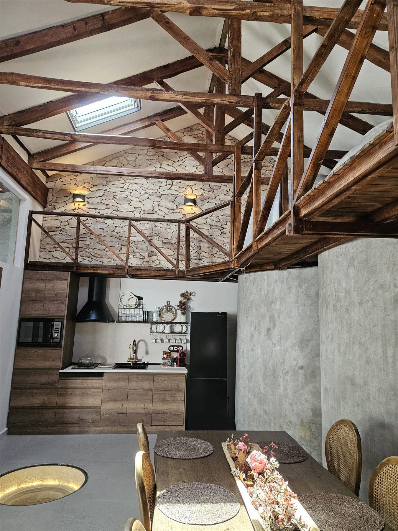 Comedor y cocina bajo la estructura de madera restaurada